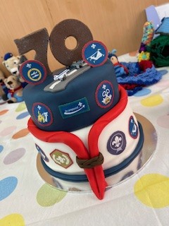 A 70th birthday cake featuring scout badges and a red neckerchief.